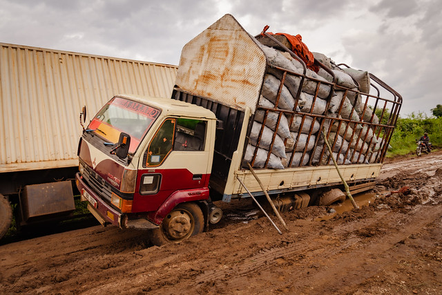Uganda, Africa - March 24, 2023: Accident scene of a large semi trucks stuck in the muddy, rutted, unpaved road