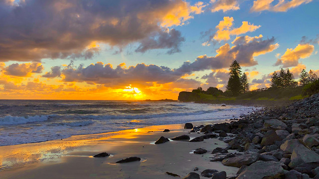 Watching the sun rise over Boulder Beach, Lennox Head, NSW, Australia on a cold winters day