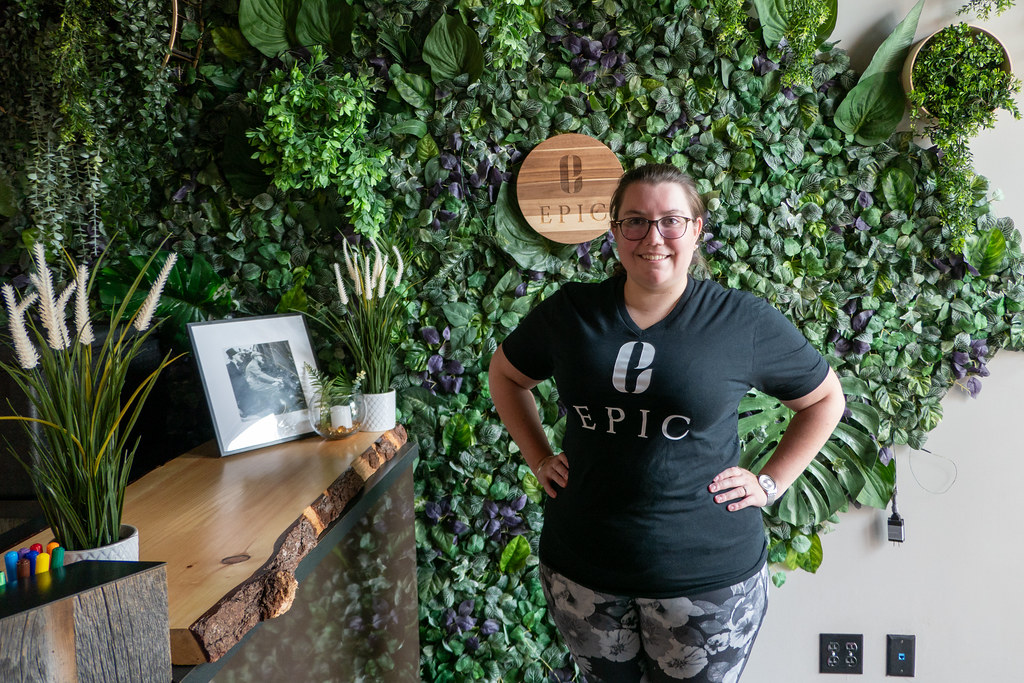 Maëlle Toews of EPIC in front of the plant-filled green wall at the downtown location