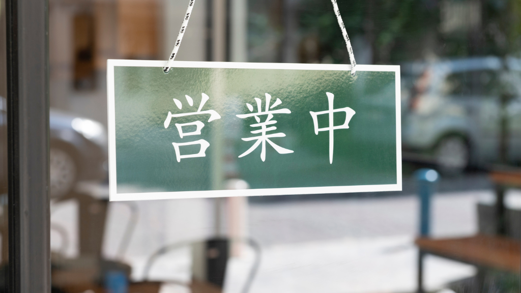 Sign saying 'open' in Japanese language hanging in a shop window.