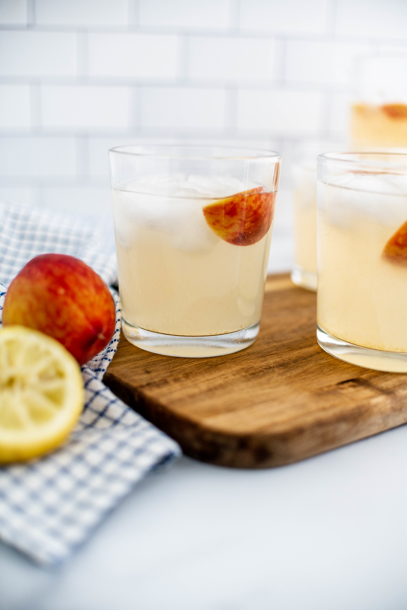 Glass of peach lemonade with a peach slice garnish.