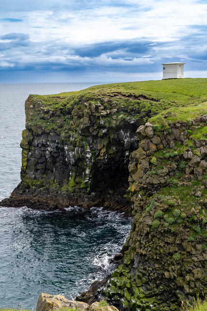 Distant view of the white Arnarstapi Lighthouse in Iceland