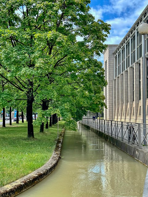 Köglmühlbach creek with trees in front of the Bavarian state chancellery in Munich in Bavaria, Germany