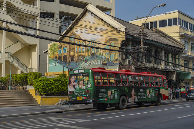City bus passing a house with an urban mural in old town of Bangkok, Thailand