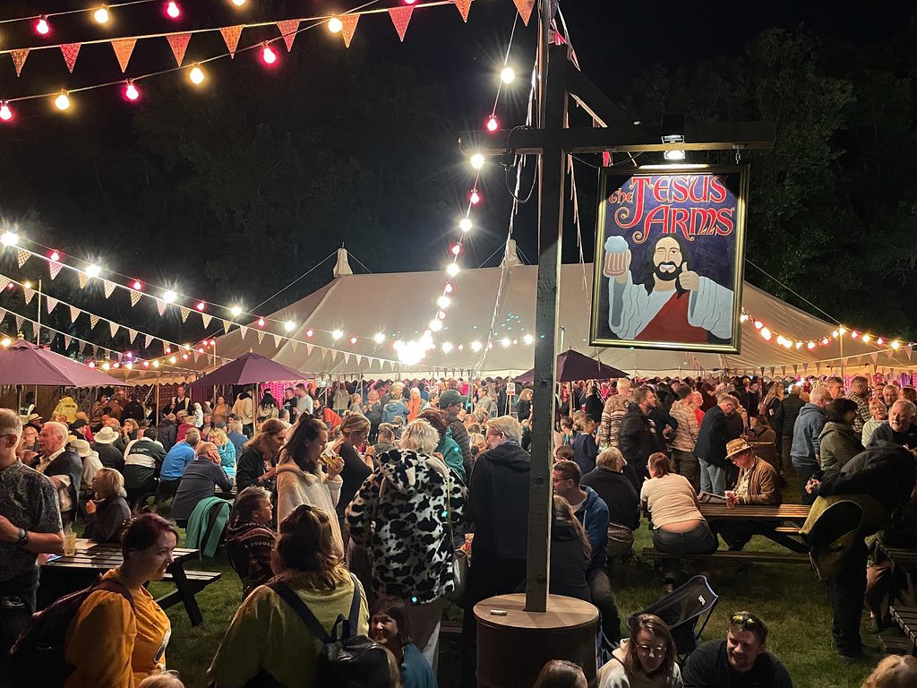 Photograph of crowded beer tent at Greenbelt Festival with pub sign reading 