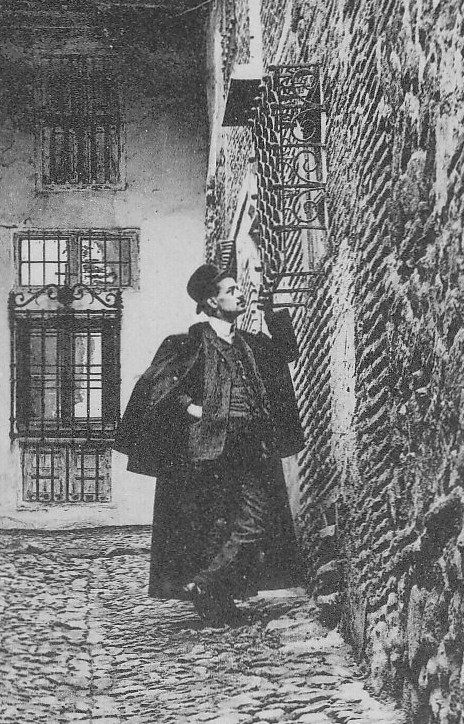 Calle de los Niños Hermosos. Curioso personaje con capa junto a una reja de forja. Detalle de una postal de Hauser y Menet.