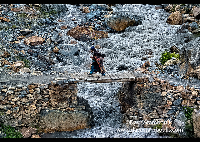 Old woman crossing a bridge into Lingshed, Ladakh, India