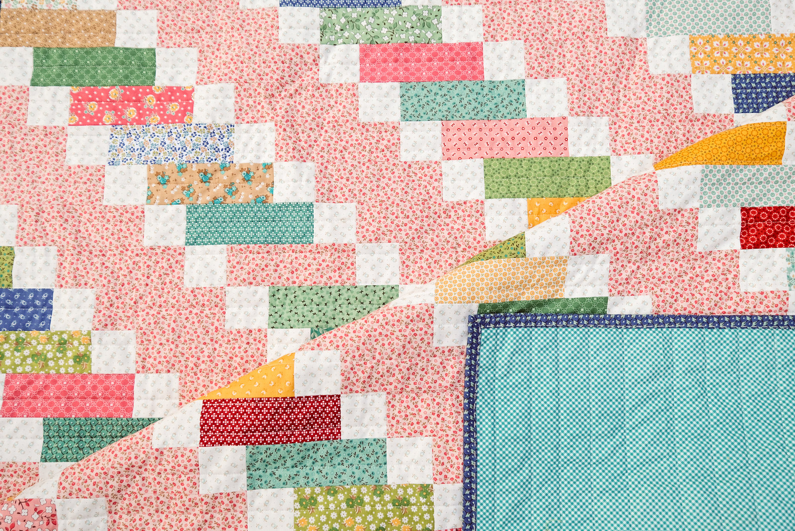 A modern traditional quilt using Home Town by Lori Holt for Riley Blake Fabrics and the Ruby Quilt Pattern by Kitchen Table Quilting. This pattern uses a Jelly Roll for a fun, quick, beginner-friendly pattern.