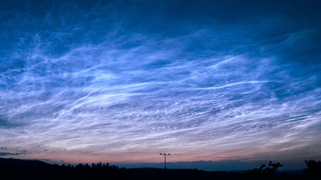 image of noctilucent clouds near 100km at the edge of space