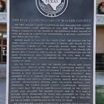 Walker County Courthouse (Huntsville, Texas) Historical marker for the Walker County Courthouse in Huntsville, Texas.  The plaque states:

The Five Courthouses of Walker County - The first Walker County Courthouse was available for county commissioners court meetings in July 1848; the building was finally completed in the center of the Huntsville public square in 1850. Because of a defective foundation, a second courthouse had replaced it by 1853. Repairs made in 1856 did not hold long. The design for the third county courthouse featured a grand jury house in the southwest corner of the grounds rather than inside the courthouse itself. Dubbed &amp;quot;The Little Courthouse,&amp;quot; the grand jury house was completed and in use by 1861. Construction on the main courthouse was interrupted by the Civil War; it was finished in 1869 but major repairs were necessary within a couple of years. On the first day of 1888 the grand jury house was again called into service after the main courthouse burned. The commissioners court selected Eugene T. Heiner of Houston to design a new building. The construction contract was awarded to D. N. Darling of Palestine. Darling set to work in late spring and erected Heiner&#039;s vision, replete with Victorian Gothic, Renaissance Revival and Italianate details. That structure, the fourth Walker County Courthouse, gradually welcomed back the social and religious groups of the county. Other uses included the Walker County Fair of 1912 and a lecture series sponsored by Texas A &amp;amp; M University in 1914. The interior of the building burned in 1968. At that time, it was one of the 25 oldest courthouses in the state of Texas. The fifth Walker County Courthouse, a modern brick and steel structure, was completed in 1970. It remained in service at the dawn of the 21st century. (2000)