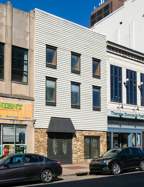 A commercial building from 1906 was given a fashionable new façade of painted wooden siding and artificial fieldstone veneer.
