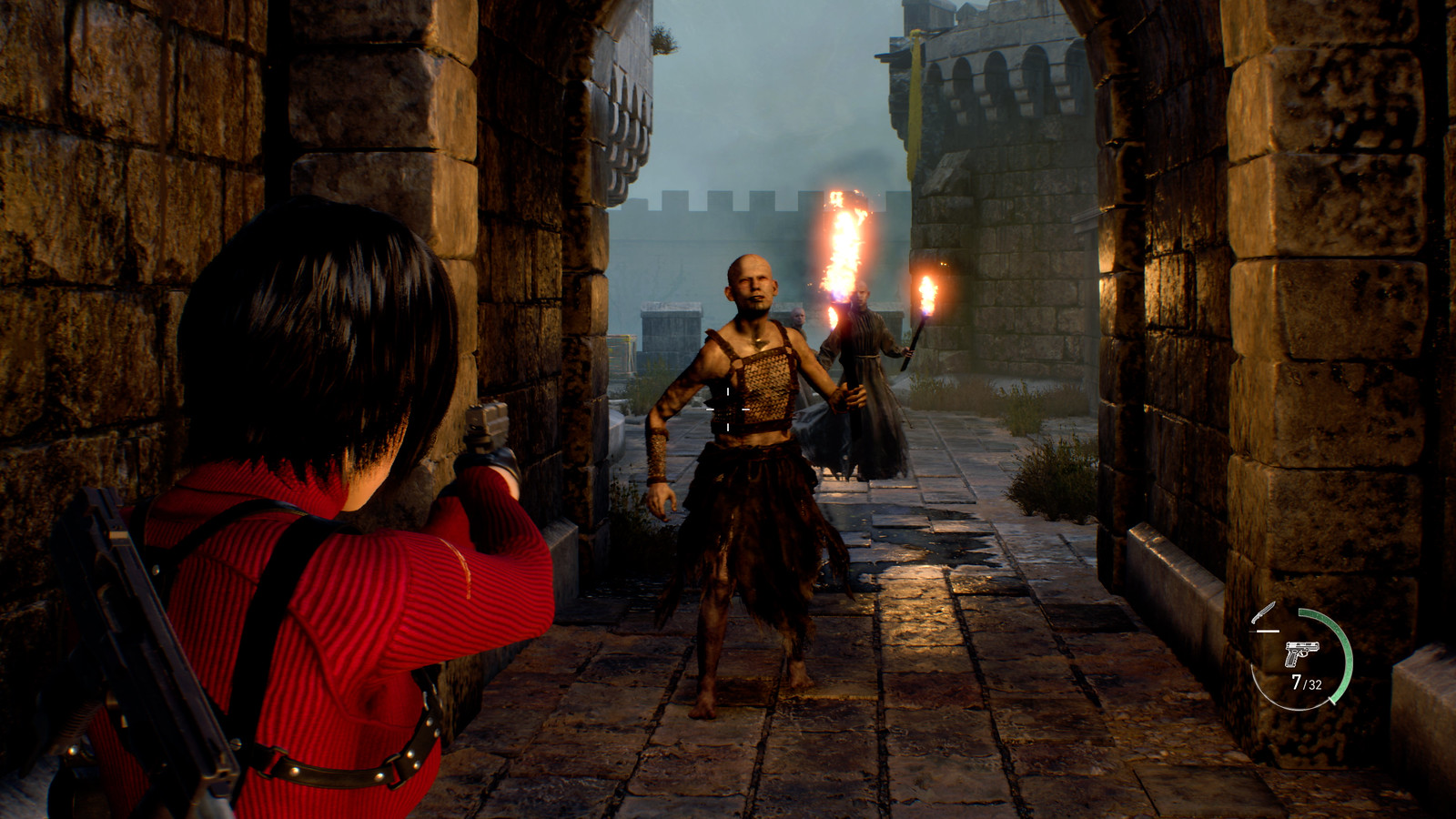 Ada Wong readies her handgun at a torch-carrying enemy as the two stand underneath a castle’s exterior archway corridor.