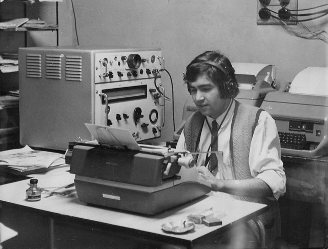 Un periodista arma su crónica en una máquina de escribir tradicional, no había electricas a eso de 1967, fíjate en el frasco de goma para copiar y pegar textos