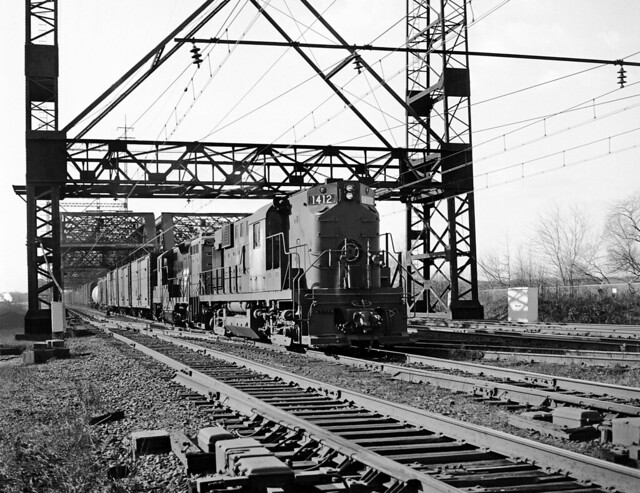 Penn Central ex New Haven Railroad ALCO RS-11 diesel electric locomotive 1412 along with an EMD GP9 with their eastbound freight train have just crossed the Housatonic River Bridge at Devon, Connecticut, 1969