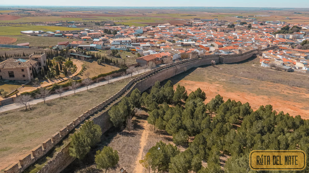 Muralla de Eugenia de Cortijo que se puede observar si vas a visitar el Castillo de Belmonte. Desciende hacia el pueblo, del cual se pueden ver los tejados anaranjados.
