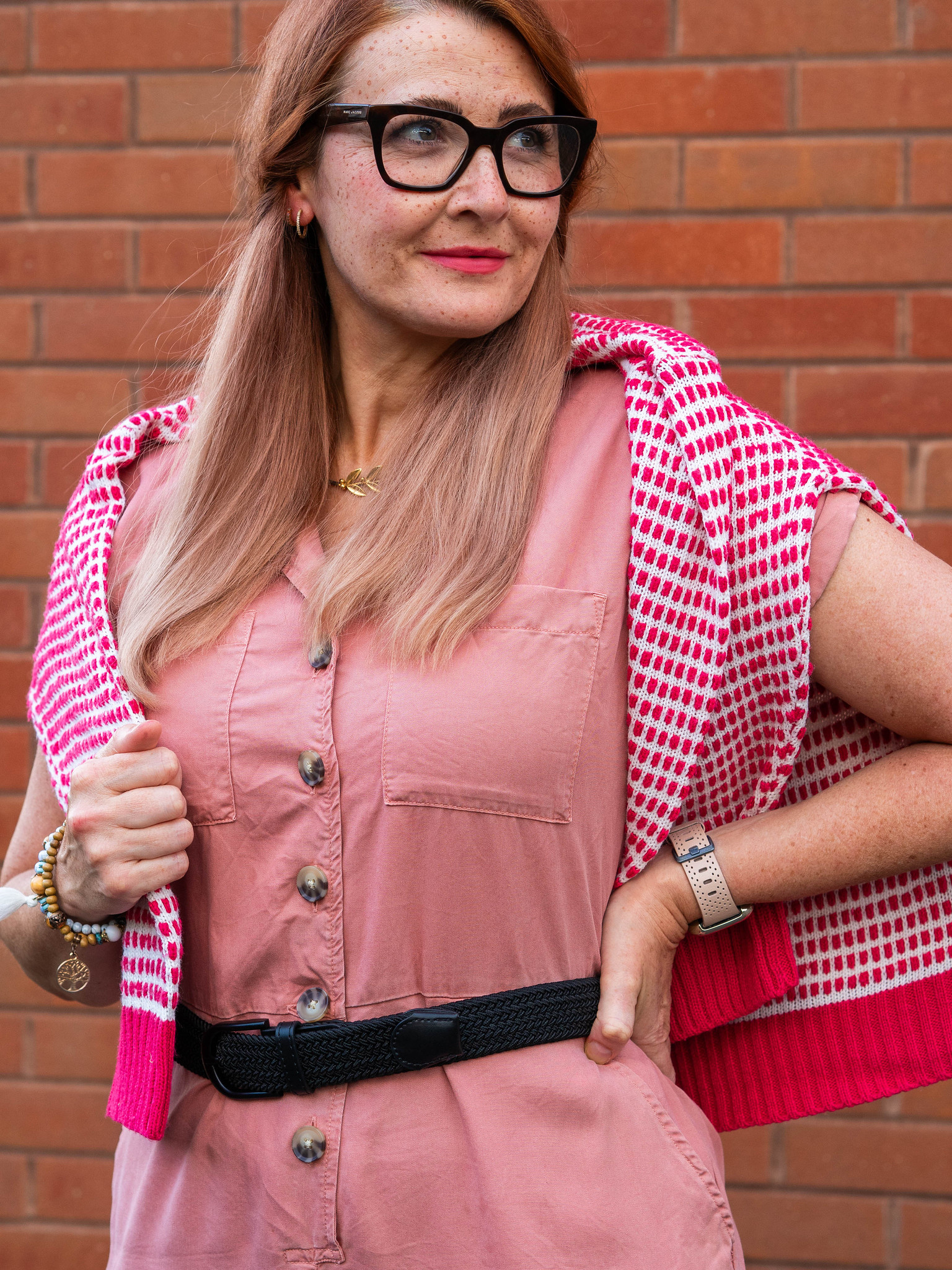 Second Hand September: Things I’ve Worn and Rediscovered (Catherine Summers aka Not Dressed As Lamb in a rose pink jumpsuit, red and white patterned sweater, black belt and flats, and colorful striped shopping bag)