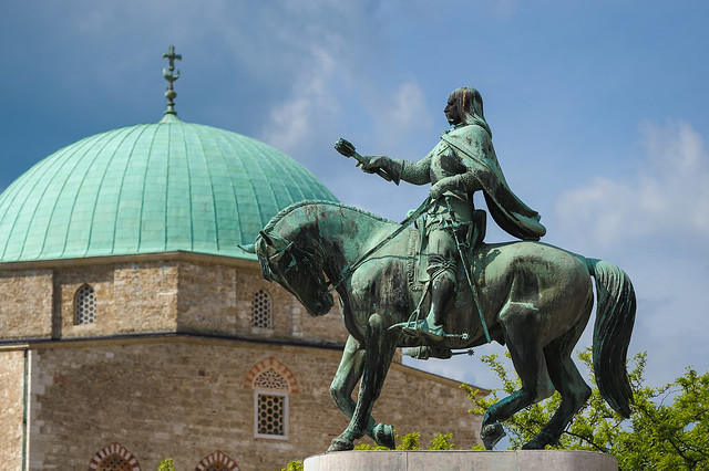 Statue od Janos Hunyadi in Pécs, Hungary (with Qasim Pasha mosk in the background)