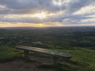 Bench, sunset view over Herefordshire atop Worcestershire Beacon, Malvern Hills, England