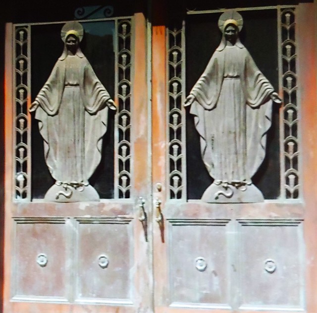 Vintage sculpture of Mother Mary on the doors of a Catholic Church in the New York City