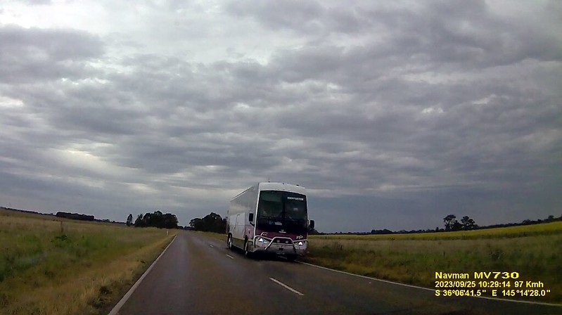 A V/Line coach driving down a road in northern Victoria