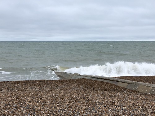Waves crashing under a grey sky on Brighton beach