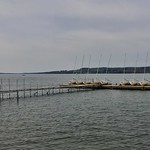 April 27, 2021: Chautauqua Lake at Richard O. Hartley Park, Lakewood, New York The view from Richard O. Hartley Park in Lakewood, New York on a pleasant spring afternoon in includes the municipal boat launch, where about a dozen watercraft are lined up waiting to be rigged and launched.