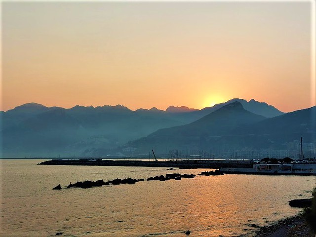 Salerno - il sole scende dietro le montagne e colora il mare di splendidi riflessi dorati