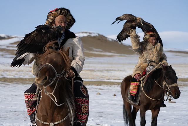 Ethnic Kazakh eagle hunters riding at Golden Eagle Festival