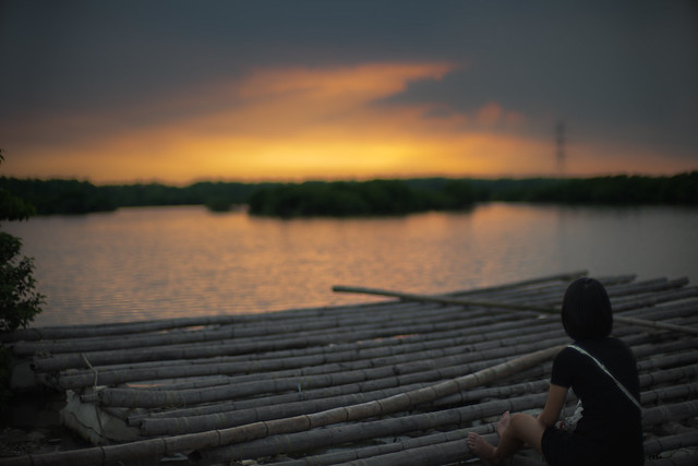 Sunset , water,  bamboo raft and a girl