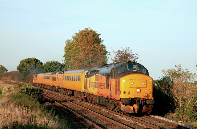 With signs of Autumn in the low sun Colas. Rail Class 37 No 37421 leads 1Q90 1515 Derby R.T.C.(Network Rail) to Ferme Park Recp. test train past Langham on 9.10.23 test train. Class 37 No 37099 is at the rear