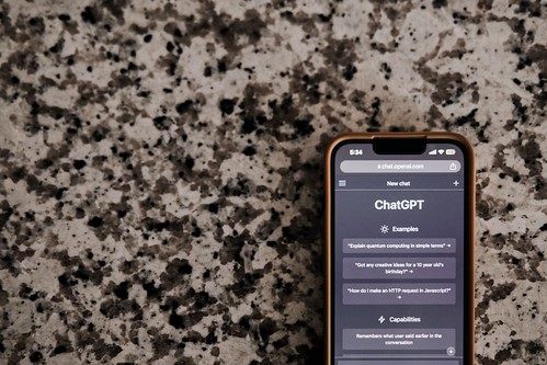 An iphone displaying a ChatGPT screen sits on a marble countertop - How to use AI/ChatGPT Effectively for Your College Application Essays