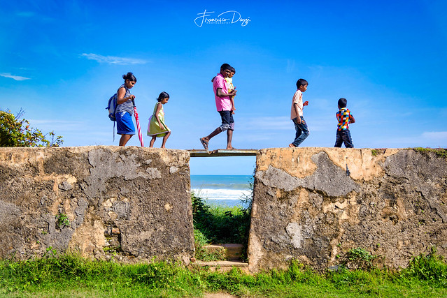 Sri Lankan family walking along the Galle old fort walls
