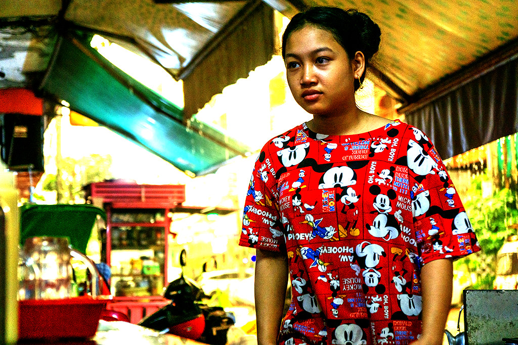 Girl in Mickey Mouse and Donald Duck shirt at sidewalk cafe on 10-28-23--Phnom Penh copy
