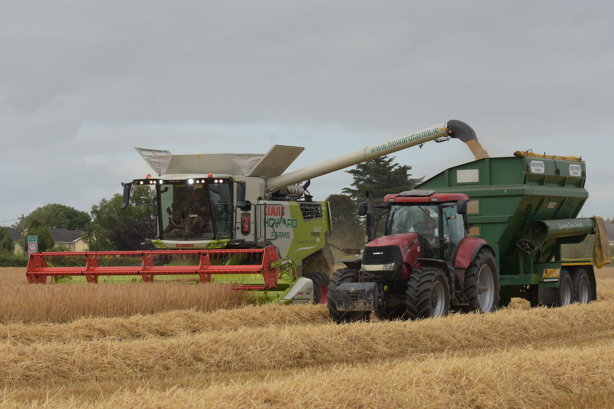 Claas Trion 650 Combine Harvester unloading Winter Barley to a Richard Weston FR16 Chaser Bin drawn by a Case IH Puma 225 CVX Tractor