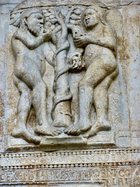 Románicos Adan y Eva comiendo del fruto del árbol prohibido del exterior de la Basílica de San Zenón de Verona. Italia