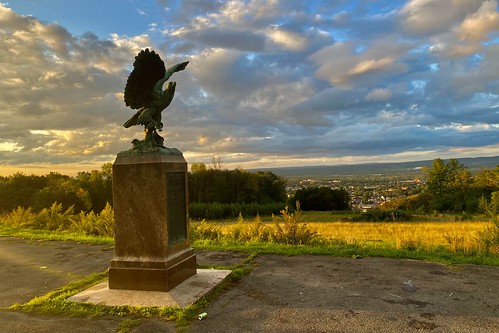 "The Eagle", Roscoe Conkling Park, Utica, New York, September 2021 Standing on a high ridge at Roscoe Conkling Park with a commanding view over the downtown skyline of Utica, New York is the city&#039;s arguably best-known piece of public art: &lt;i&gt;The Eagle&lt;/i&gt;, a six-foot bronze statue of the titular bird sculpted in 1923 by noted artist Charles Keck. A pair of bronze plaques embedded in the marble pedestal relate that the monument was dedicated in memory of prominent hotelier, industrialist and politico Thomas Redfield Proctor (1844-1920), describe Proctor as &amp;quot;an incorruptible citizen and a pure patriot&amp;quot; who, &amp;quot;if asked what he wished in reward for any good public deed... answered &#039;I want nothing&#039;&amp;quot;, and relate the incident in his life that inspired the statue: gifted a caged bald eagle one Fourth of July, he ascended to the roof on Bagg&#039;s Hotel, which he owned, and freed the bird. Proctor, too, died on the Fourth of July &amp;quot;and went the way the bird did, seeking his native element and the true father of his country&amp;quot;. Another plaque on a different face of the pedestal quotes from the Book of Sirach: &amp;quot;And some there be, which have no memorial; who are perished, as though they had never been; and are become as though they had never been born; and their children after them... their bodies are buried in peace; but their name liveth for evermore.&amp;quot;

&lt;i&gt;&lt;b&gt;A NOTE ABOUT LICENSING:&lt;/b&gt; The sculpture depicted in this image is the work of an artist who died in 1951, so it falls in the public domain in its country of origin and other countries and areas where the copyright term is the author&#039;s life plus 70 years or fewer. In other jurisdictions, reuse of this content may be restricted; consult local laws for details. The composition of the photograph itself, and all other elements, are hereby licensed under the terms of Creative Commons Attribution-ShareAlike 2.0 as labeled.&lt;/i&gt;