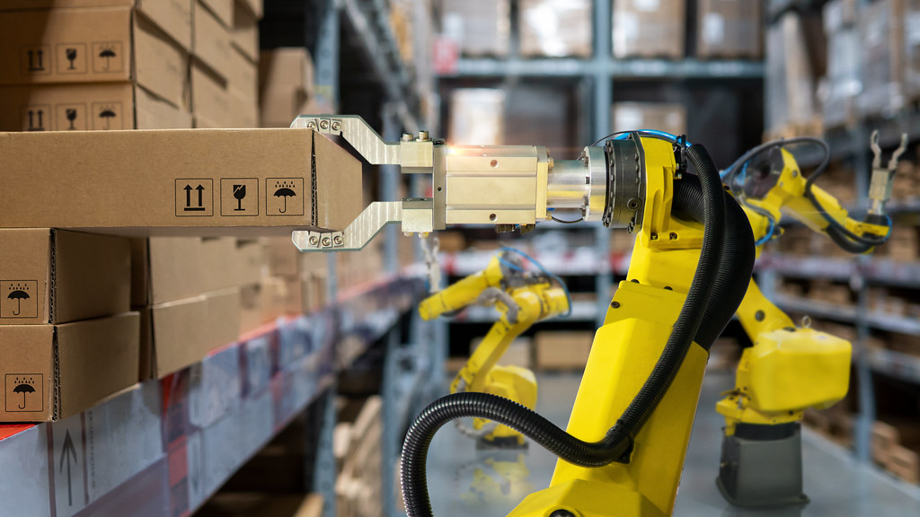 Robotic arm selects a cardboard box in a warehouse