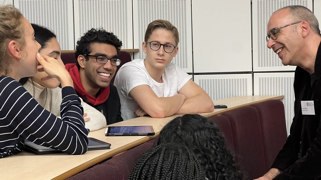 Group of seven students discussing ideas in a lecture theatre