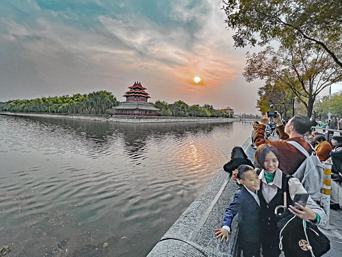 China 2023. Beijing. Walkers taking selfies along the moat of the Forbidden City at Sunset. by Jean-Paul Margnac, Chine 2023. Pékin.
Promeneurs prenant des selfies le long des douves de la Cité Interdite.margnac j