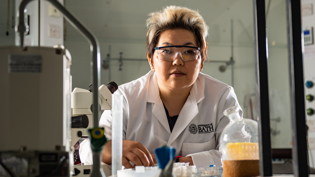 Female scientist in lab coat sitting in lab