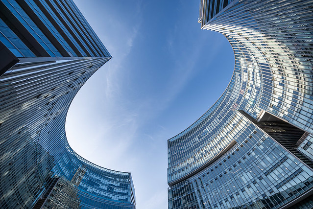 Modern curved glass buildings against clear blue sky