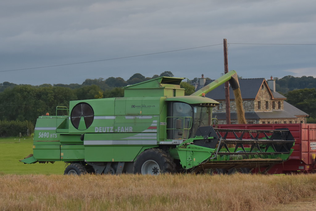 Deutz Fahr 5660 HTS Combine Harvester unloading Spring Barley to a Redrock Trailer