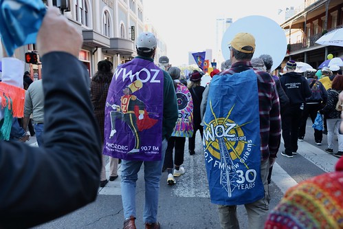 WWOZ flag capes in the second line parade to WWOZ's new location on Nov. 28, 2023. Photo by Michele Goldfarb.