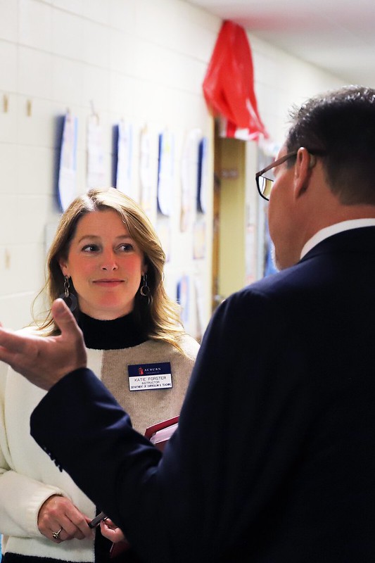 A woman smiles as she talks with a man in an elementary school