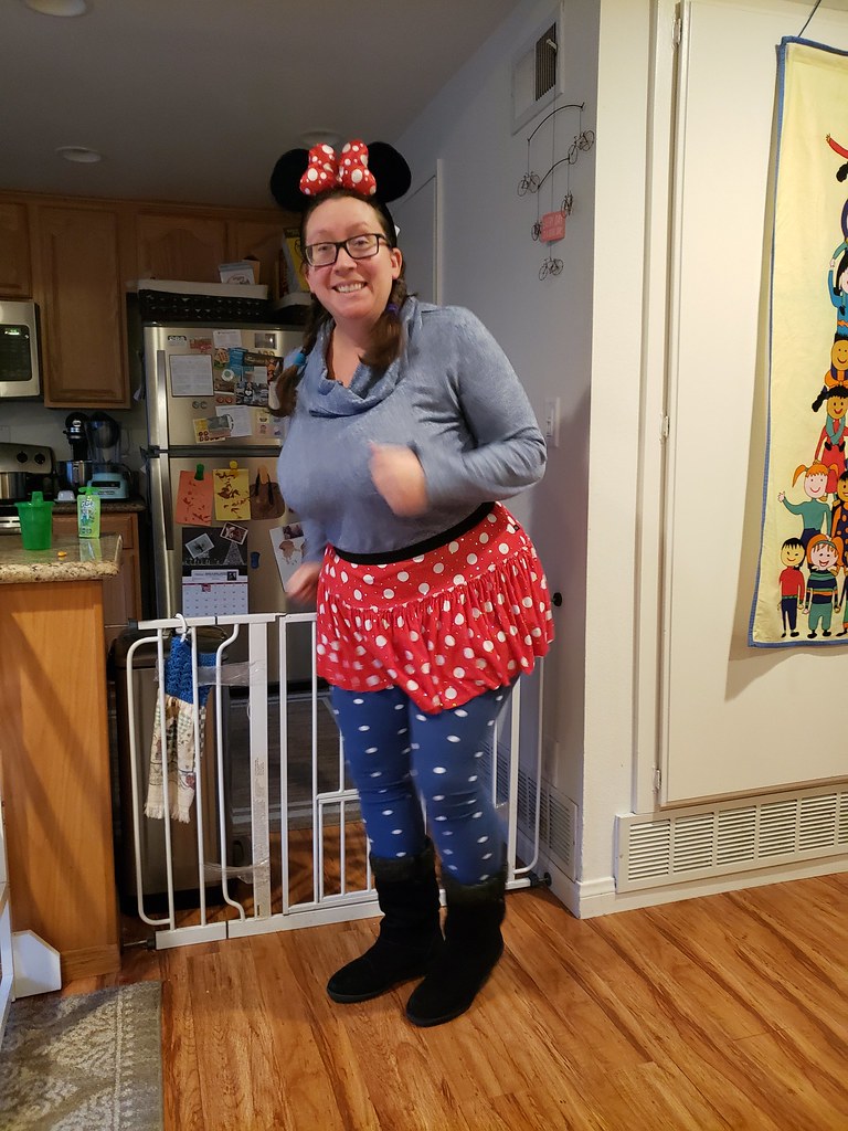 an adult woman with mouse ears and a sparkle skirt
