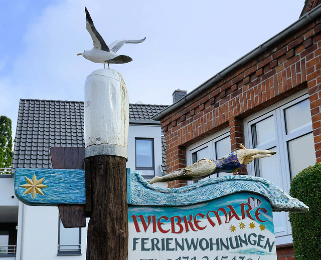 6644 Holzschild mit Schwimmerin und Möwe, Vermietung von Ferienwohnungen  - Fotos von Niendorf / Ostsee, Ortsteil der Gemeinde Timmendorfer Strand im Kreis Ostholstein in Schleswig-Holstein.