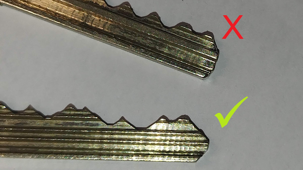 A key that has worn over time and is now rounded on the end, compared to a key that is not worn and is in working condition