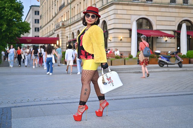 Isey; gelber Latexmini, gelbe Jacke, Netzstrumpfhose & rote high-heels