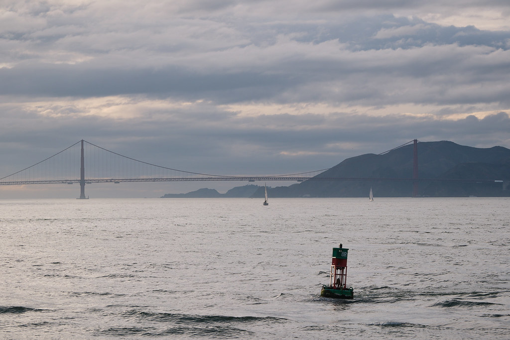 View from the water onto the Golden Gate Bridge with a buoy in the foreground