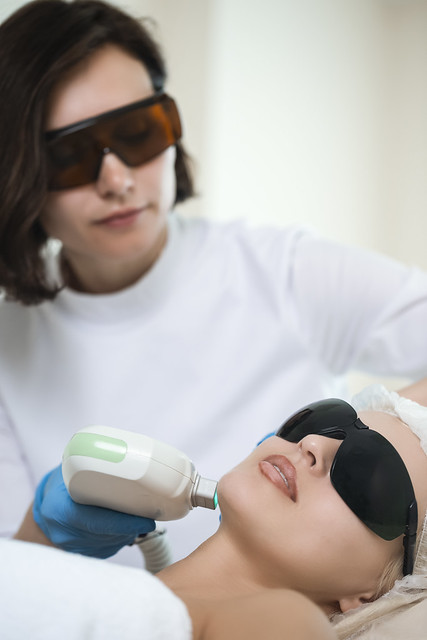 Skin treatment Concepts. Professional Cosmetologist Treating Female Human Skin With Laser Using Professional Equipment.